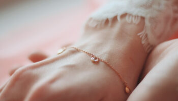 closeup-shot-female-wearing-fashionable-bracelet-with-charm-pendants