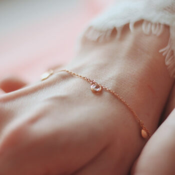 closeup-shot-female-wearing-fashionable-bracelet-with-charm-pendants